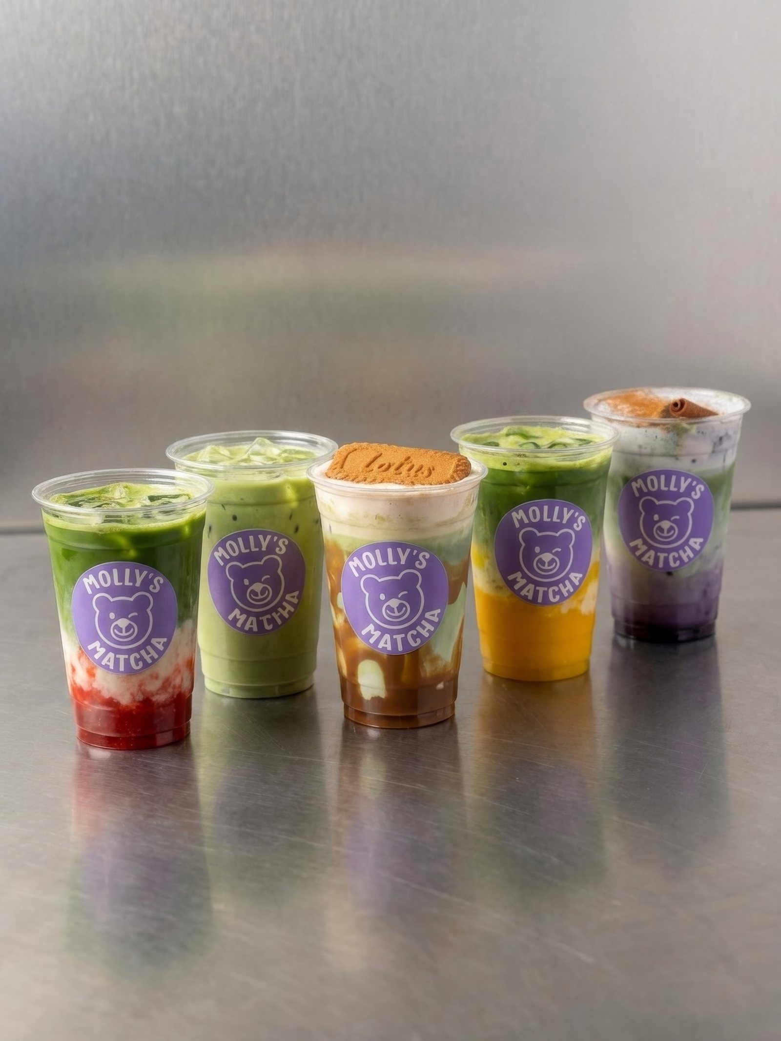 Fünf Becher von Molly's Matcha nebeneinander: Strawberry, Classic, Tiramisu, Mango und Blueberry