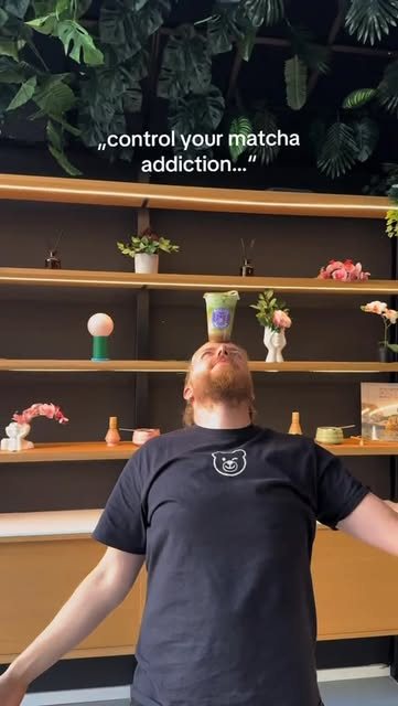 Blick in den Laden: Holzregale mit Pflanzen und Matcha-Schalen, davor ein Mitarbeiter im schwarzen Molly's-Shirt